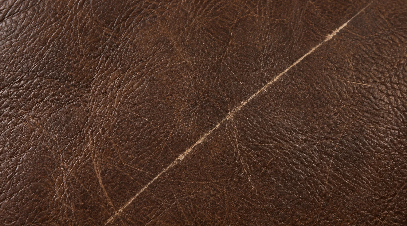 Scratch across a brown leather panel