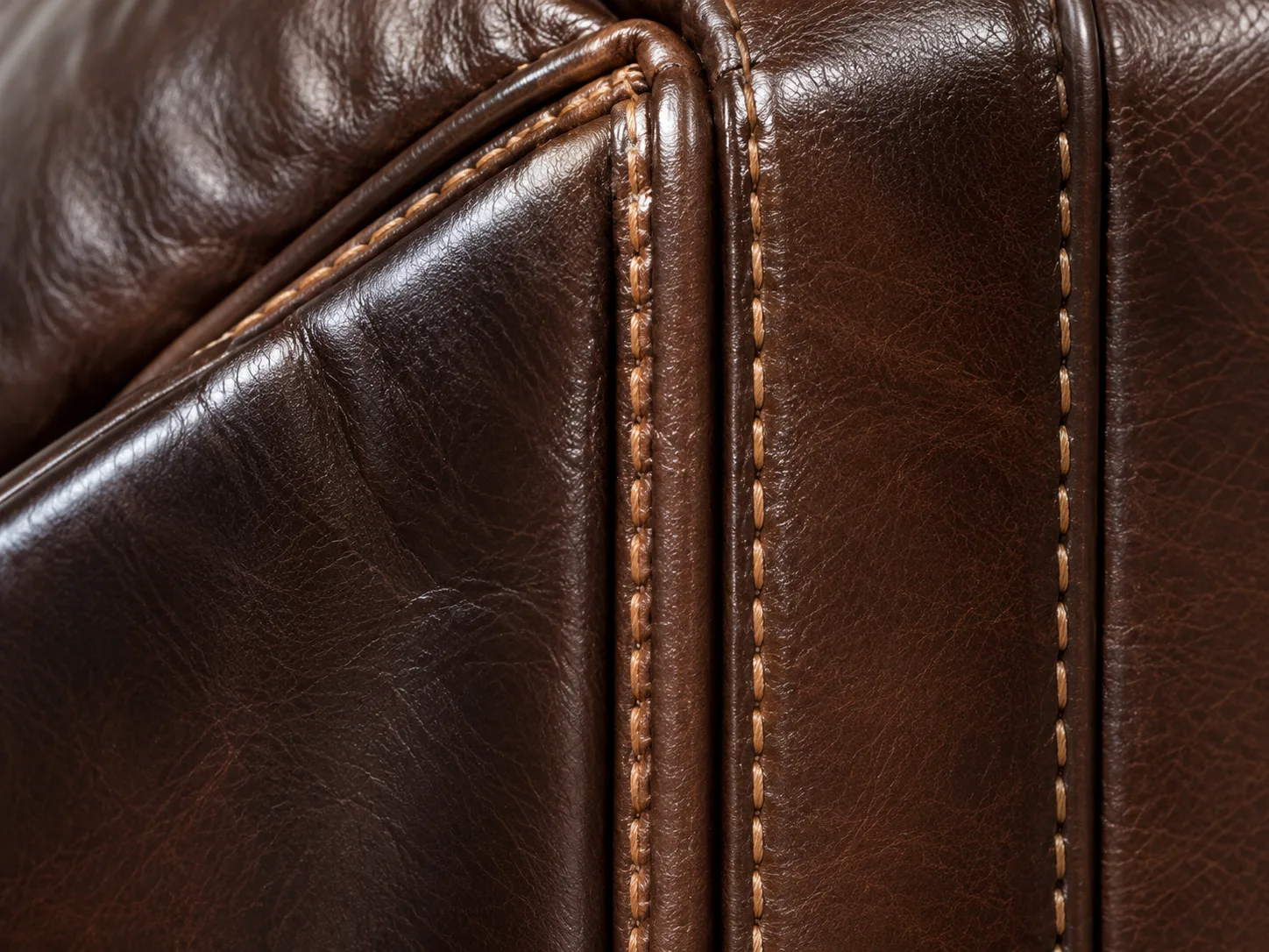 Contrast stitching along a leather seam inspected for pulled thread
