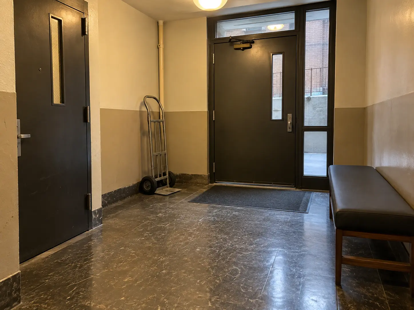 A bench in a building service entrance vestibule