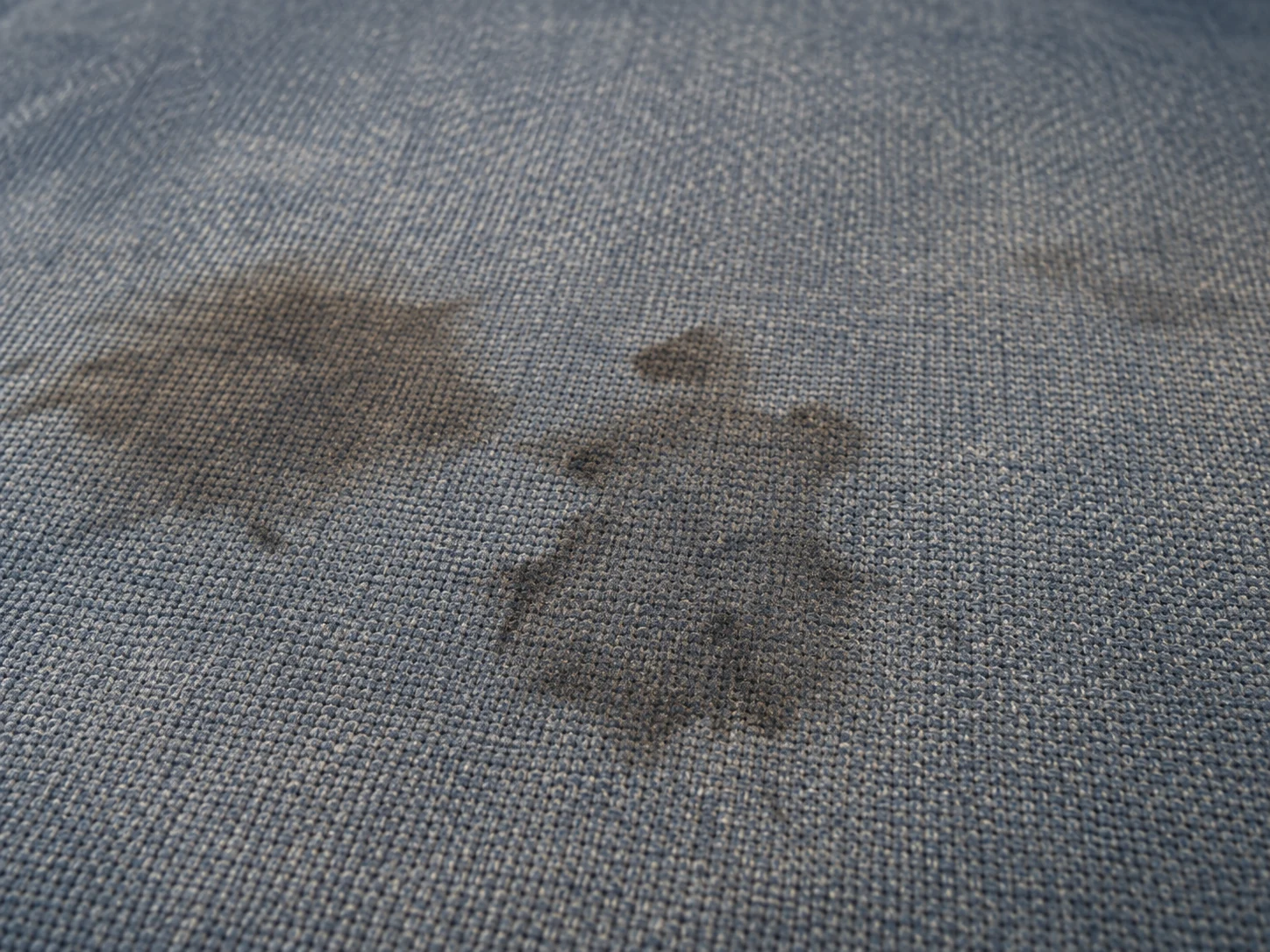 Spill stains soaked into a woven waiting room chair seat