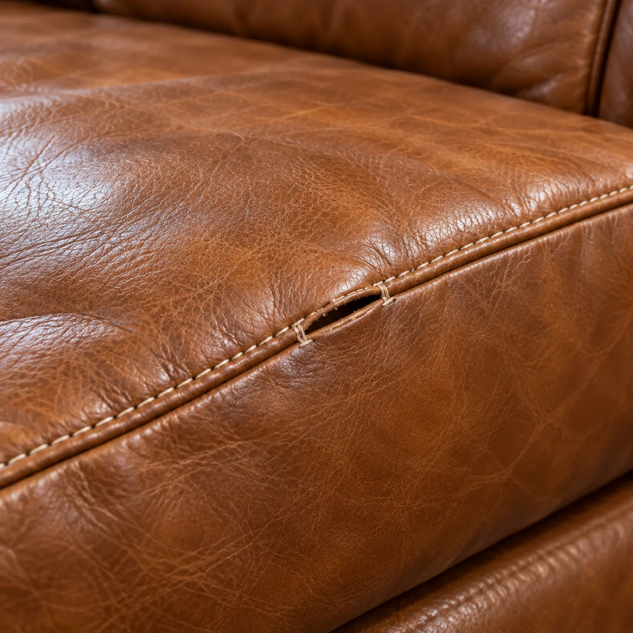 A small split along the seam of a leather couch cushion