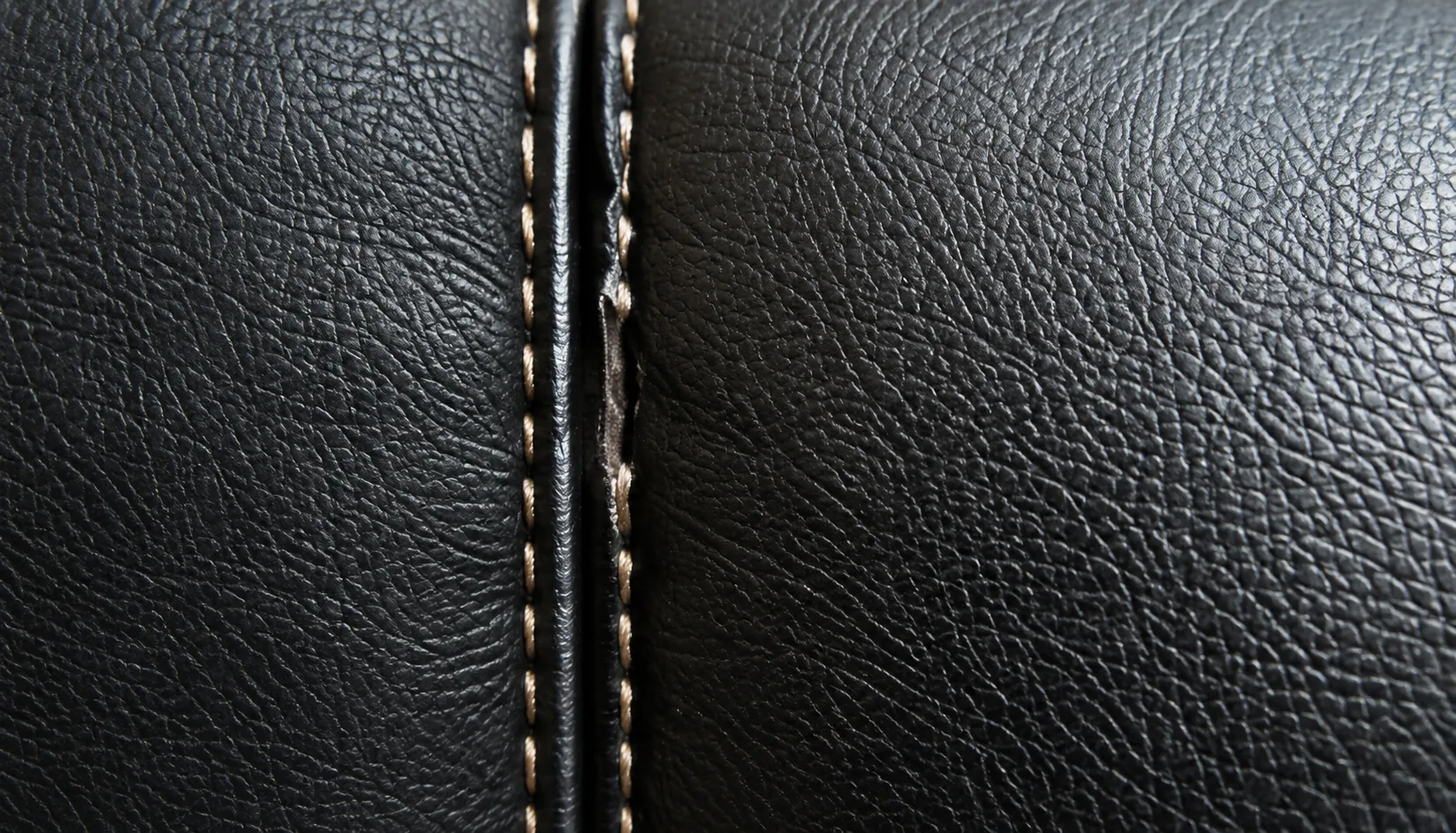Split stitched seam on black booth leather