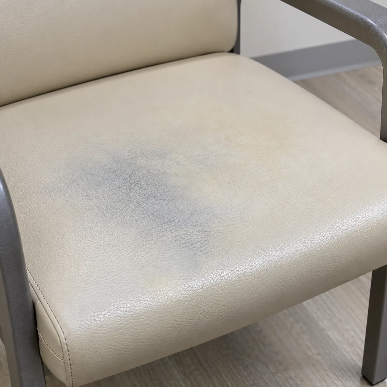 A blue dye stain on a cream vinyl waiting room seat
