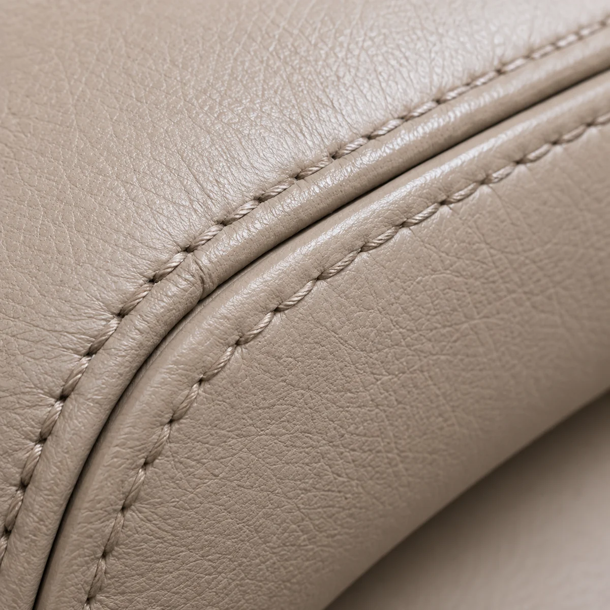 A stitched seam on taupe dental chair vinyl