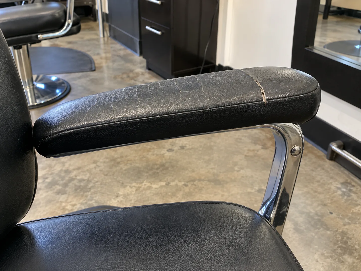A cracked styling chair arm pad before reupholstery