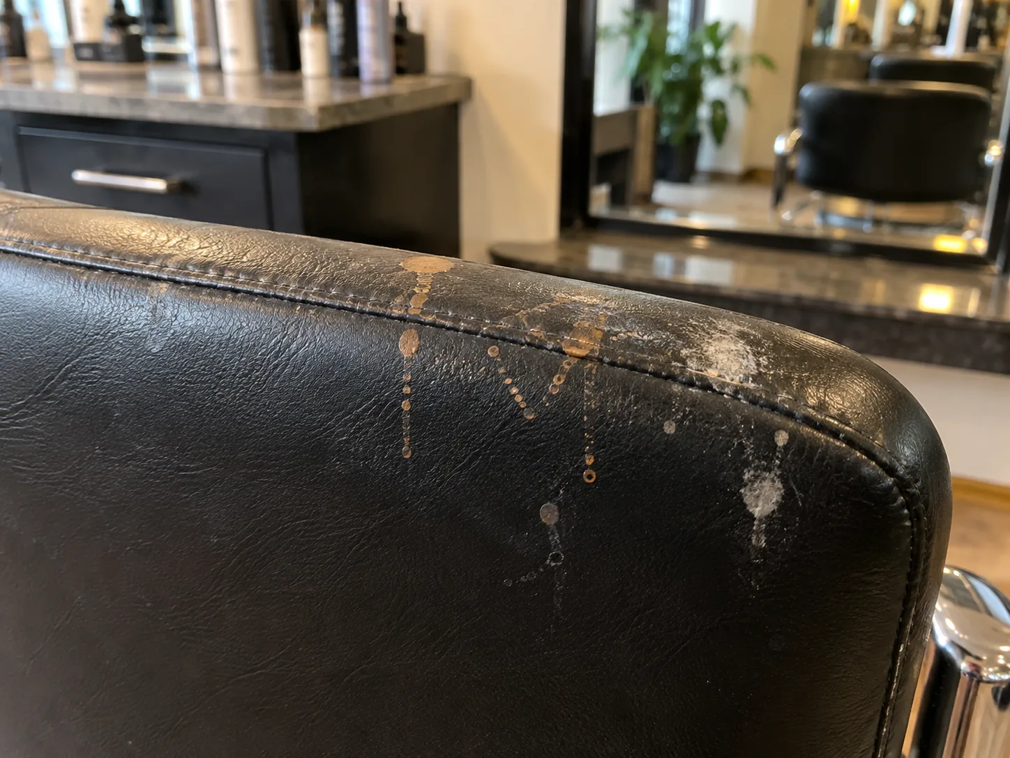 Hair colour splashes on the top of a black styling chair back