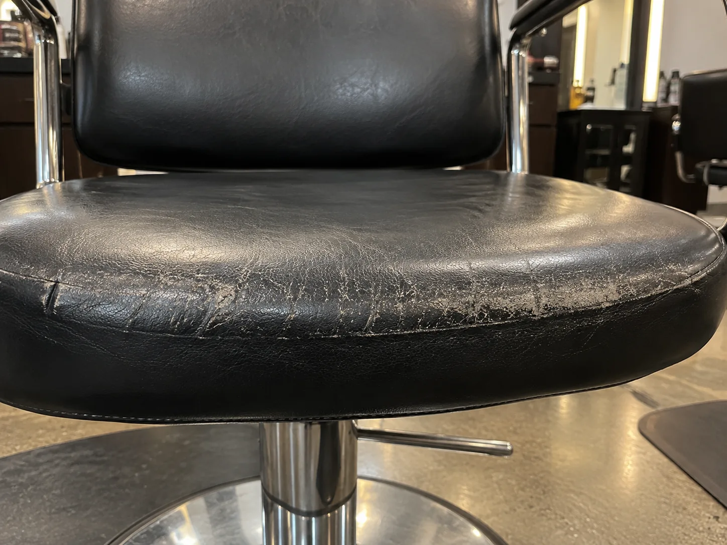 Worn vinyl on the front edge of a styling chair seat