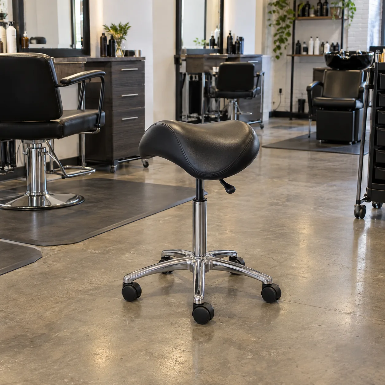 A black vinyl saddle stool for a stylist
