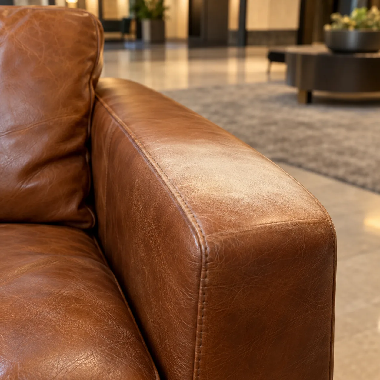 A sun-bleached pale patch on a cognac leather sofa arm