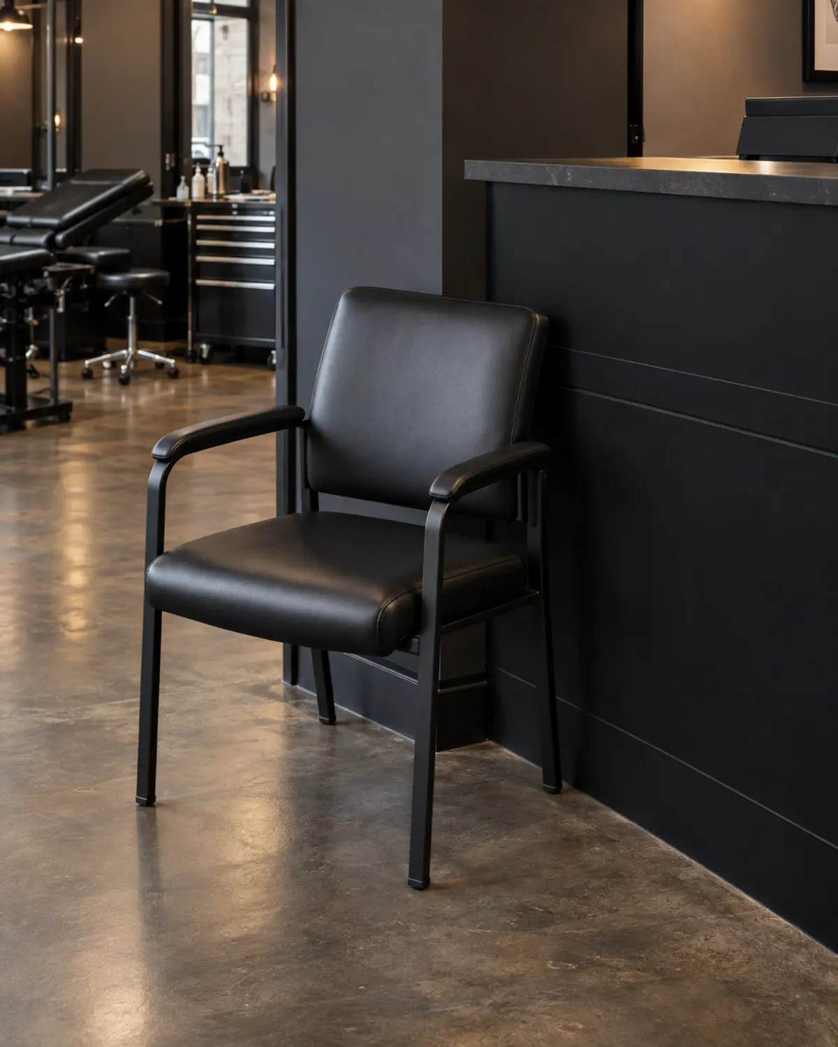 A black vinyl reception chair beside the studio front desk