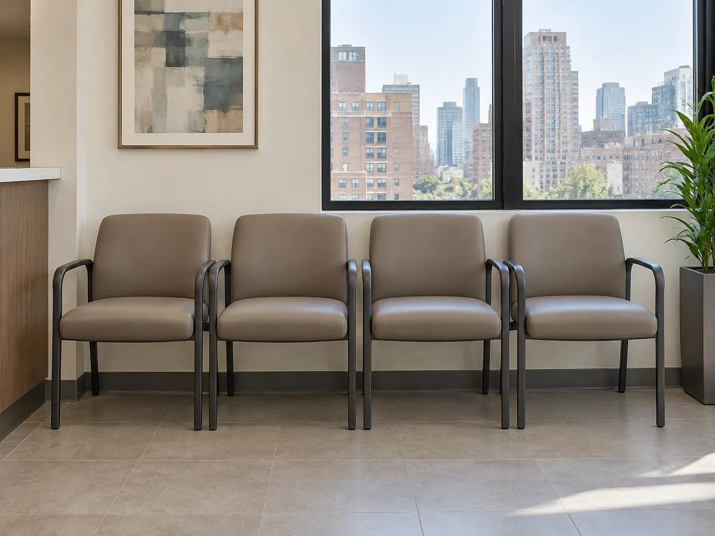 A row of four taupe waiting room chairs under a window