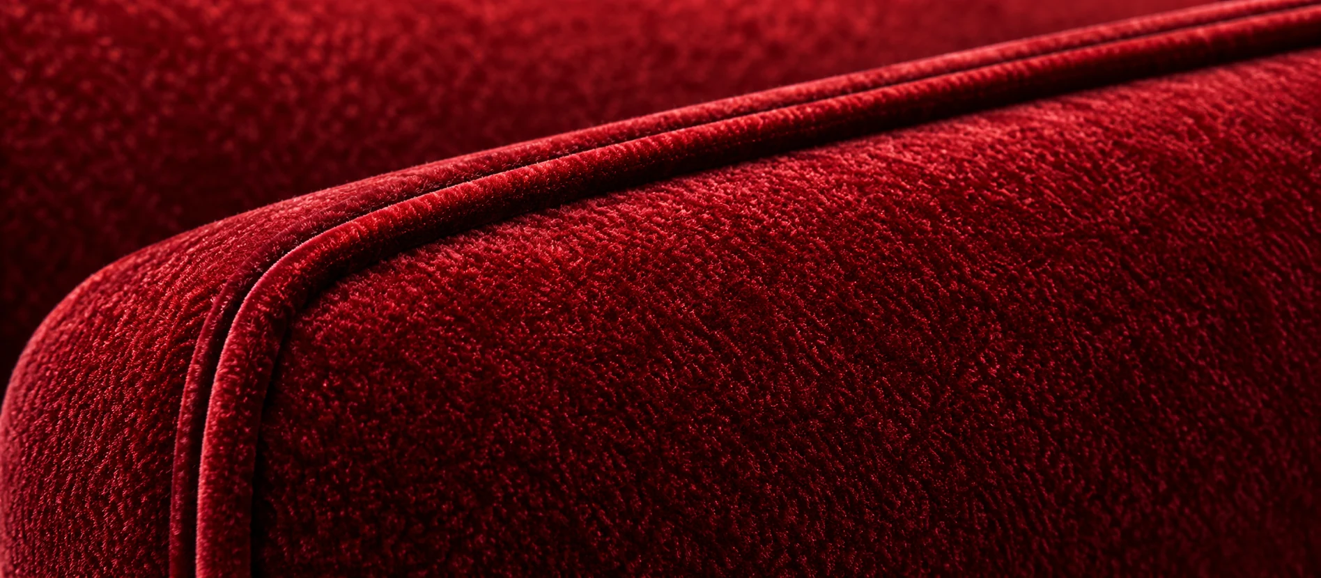 Welt and piping detail on a red velvet theater seat