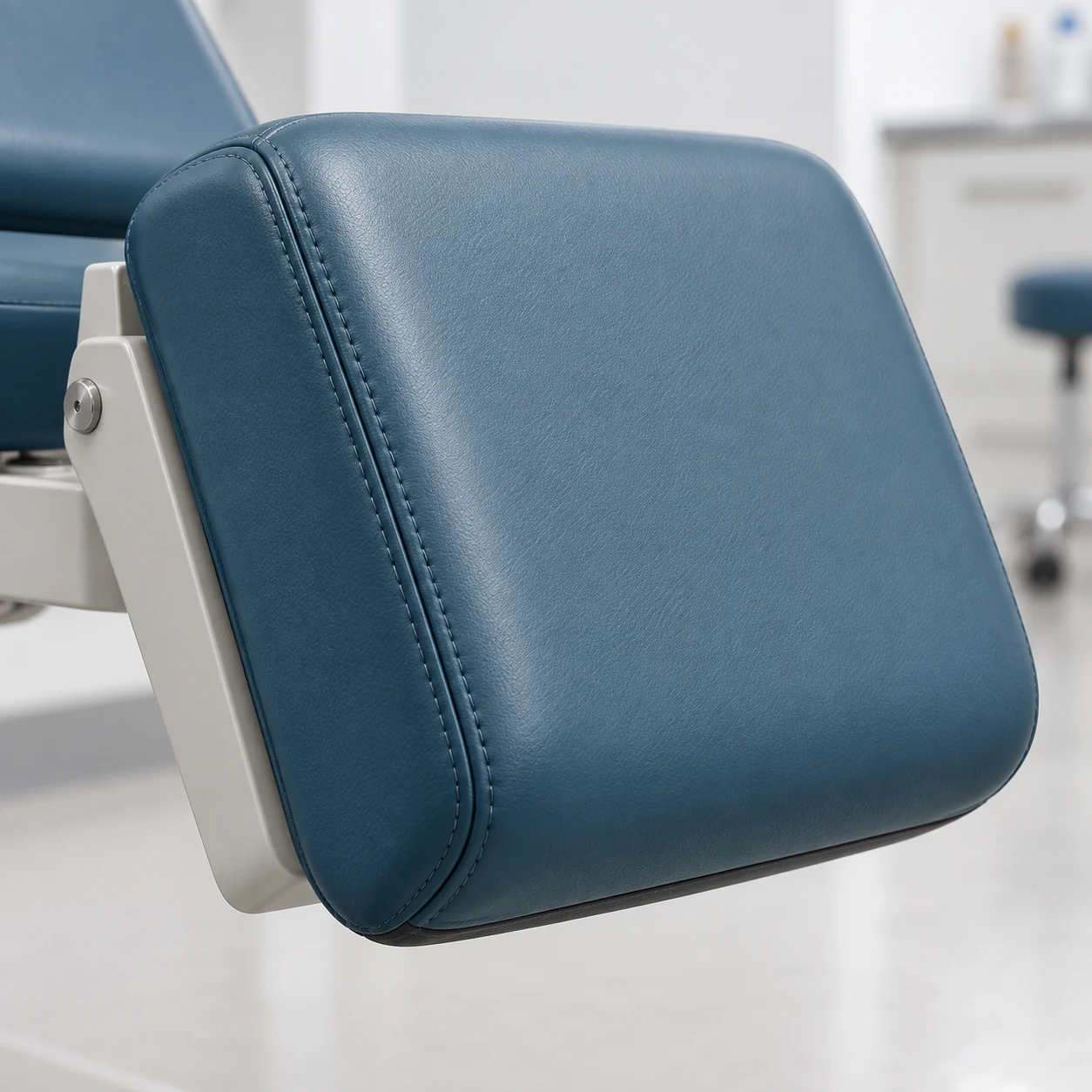 Treatment chair seat pad raised on its white steel frame