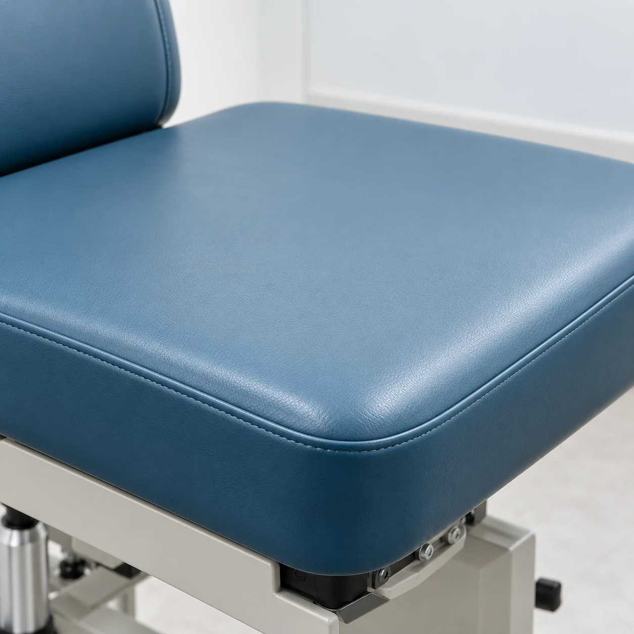 Treatment chair seat pad bolted down over the actuator hardware of a powered base
