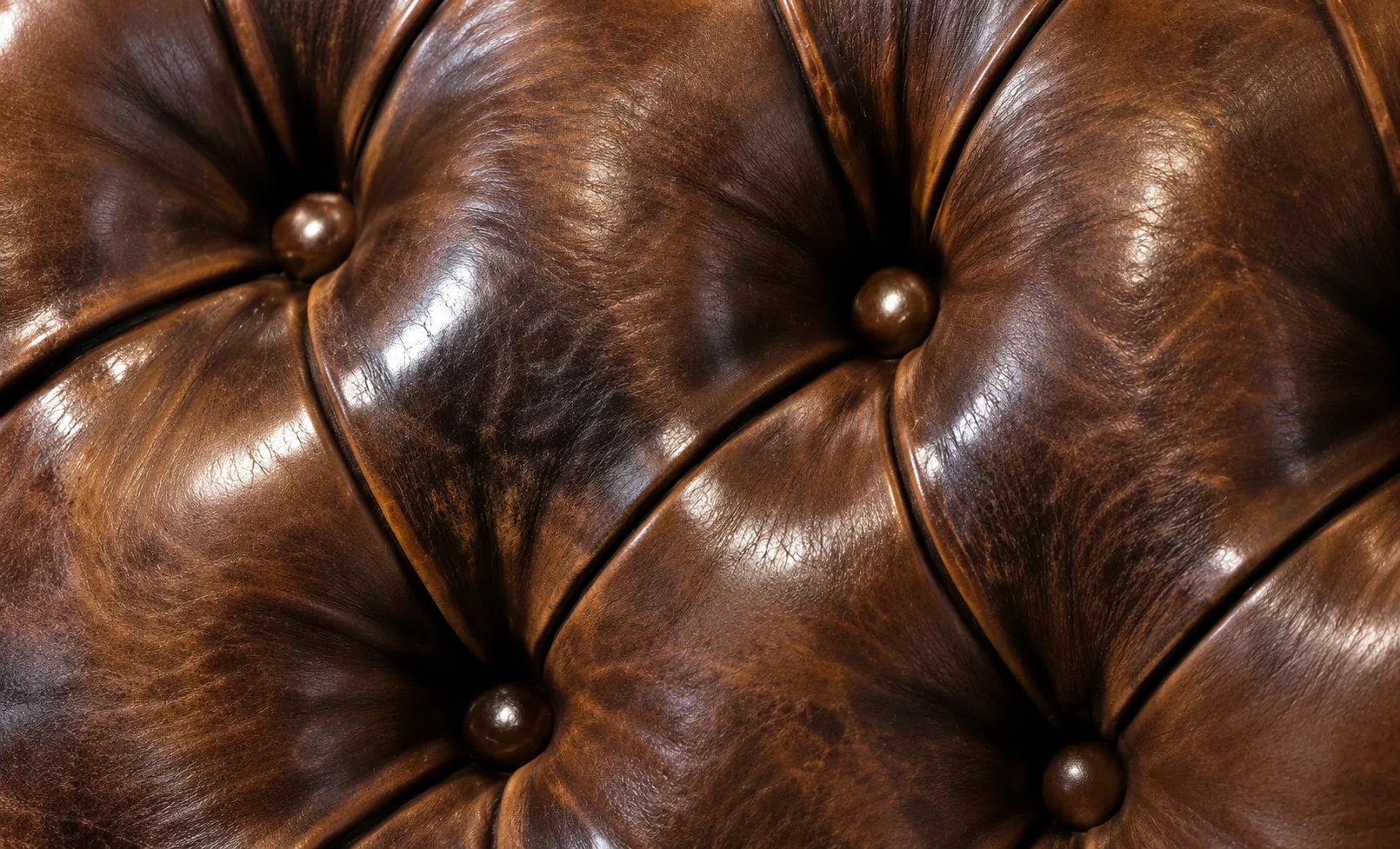 Close-up of deep button tufting on antique brown leather