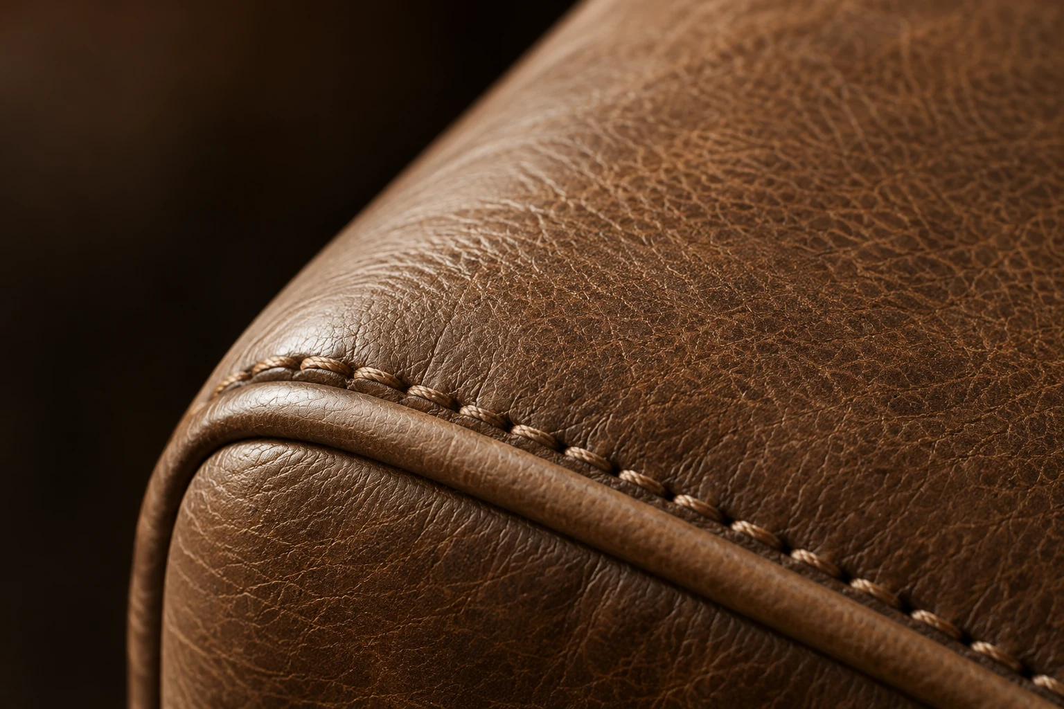 Hand-stitched welt on a brown leather arm