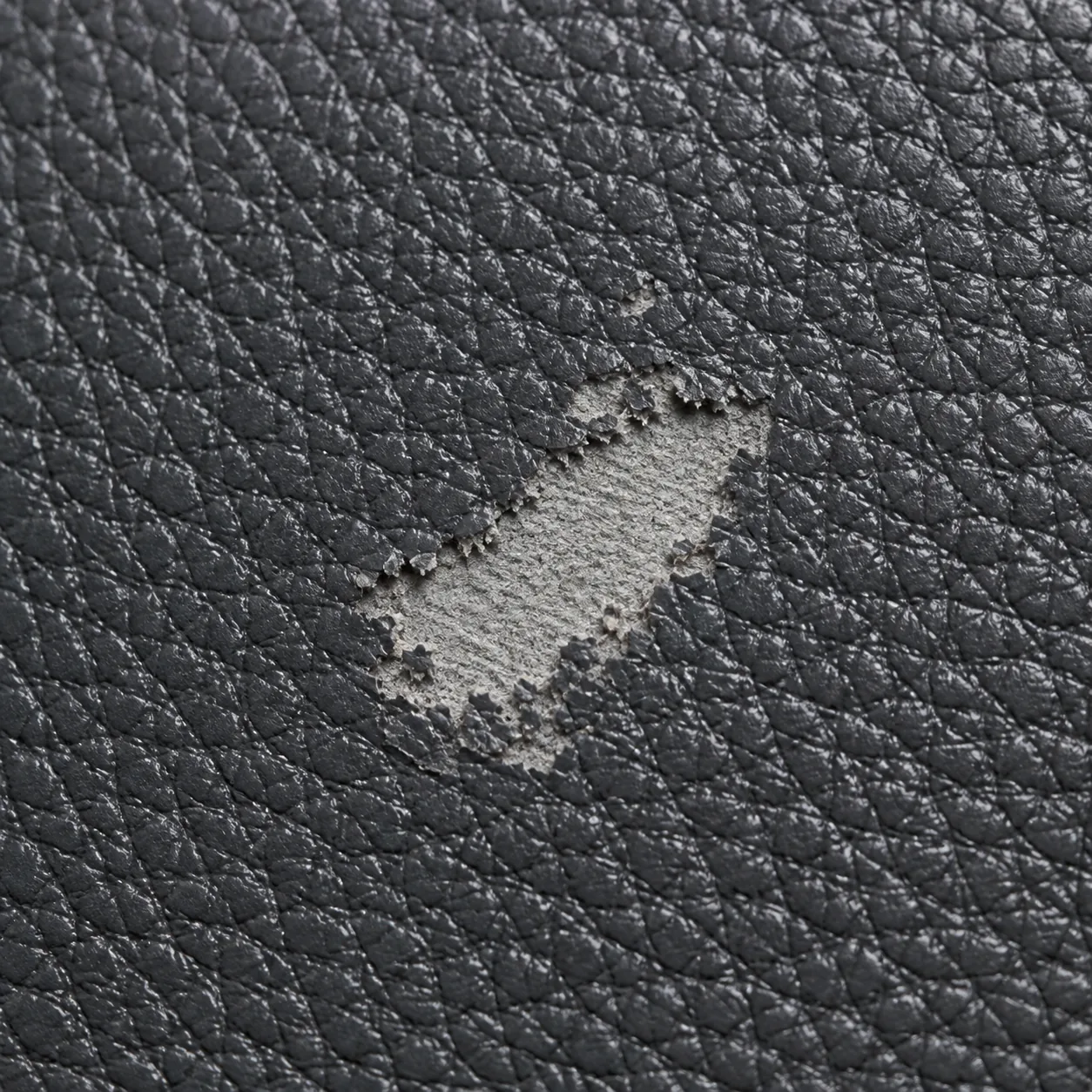 Close view of vinyl where the color layer has worn through to a paler shade