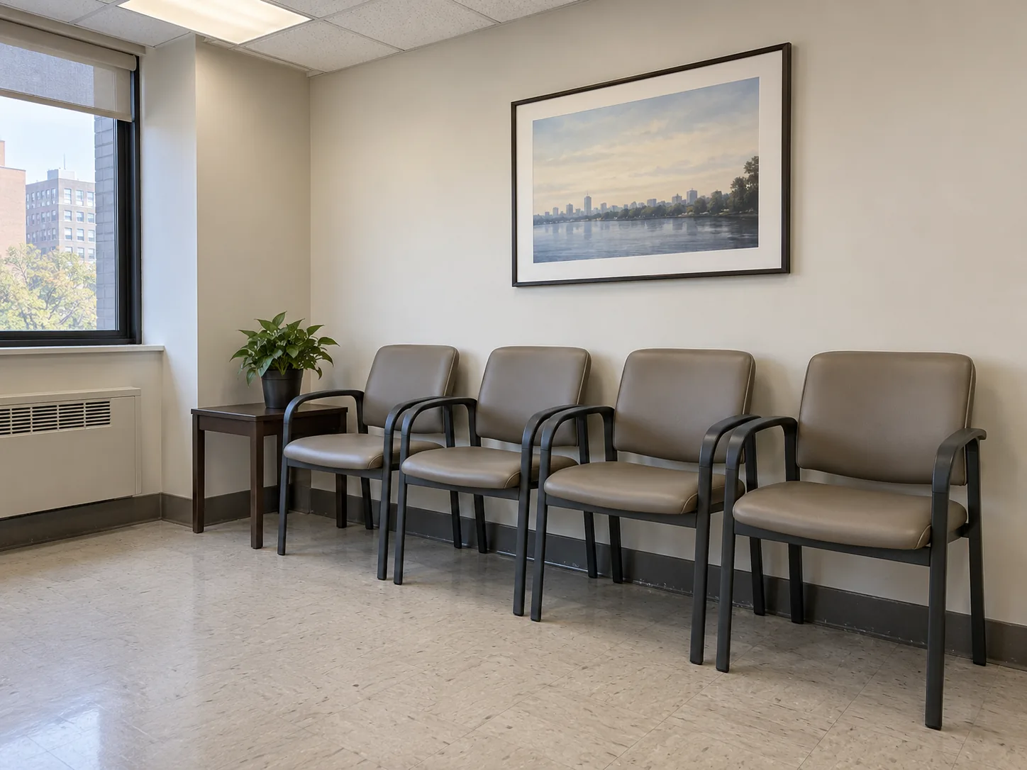 A row of taupe vinyl chairs in a medical waiting room