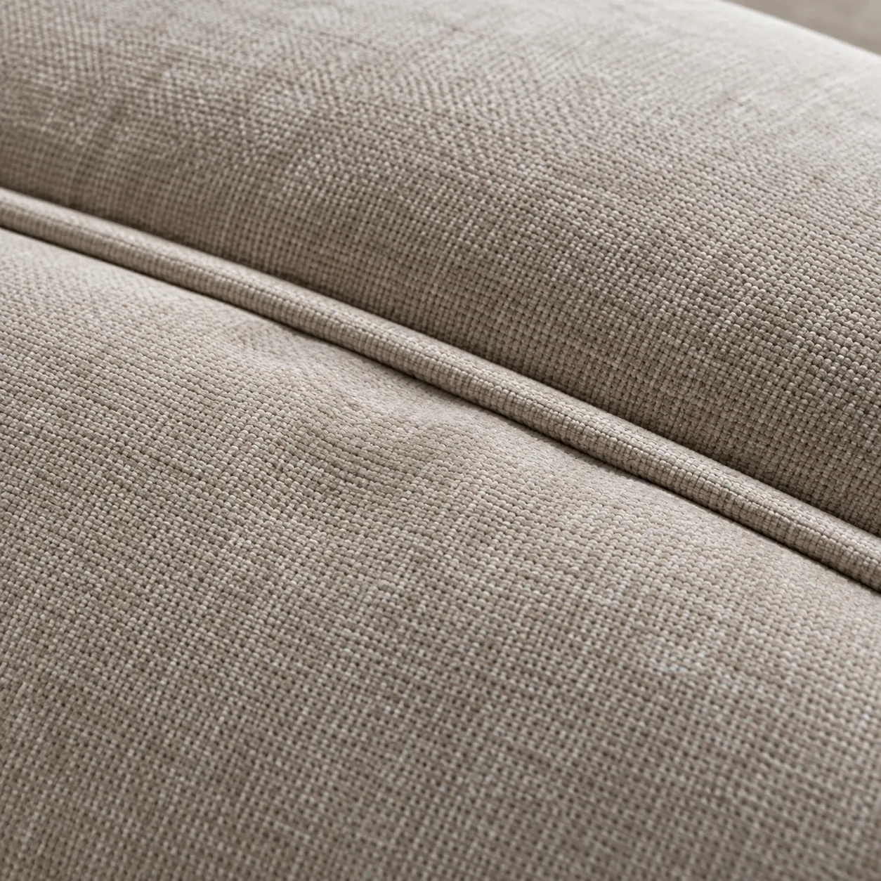 Welted seam running along the edge of a natural linen headboard