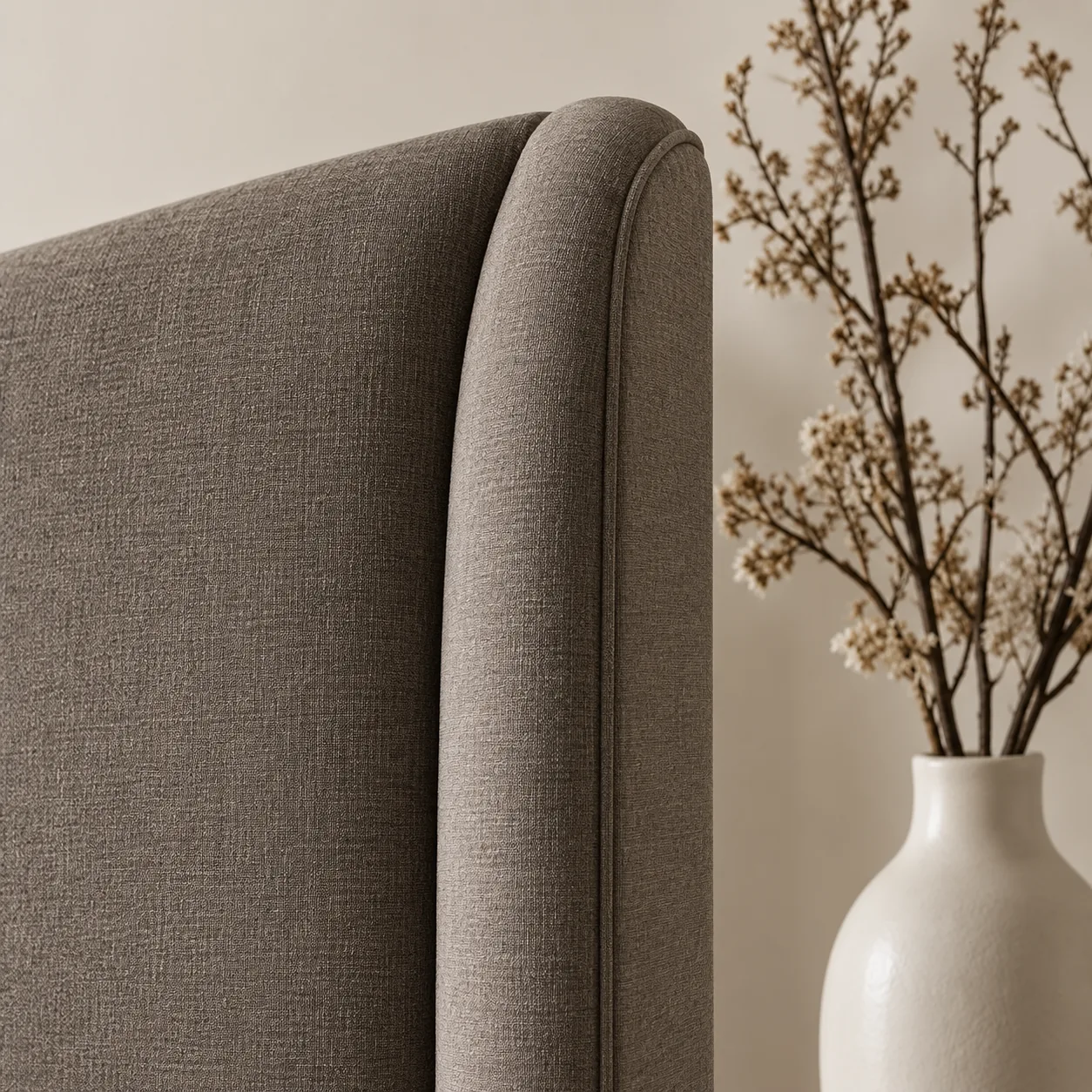 Rolled wing corner on a tweed headboard with a welt along the roll
