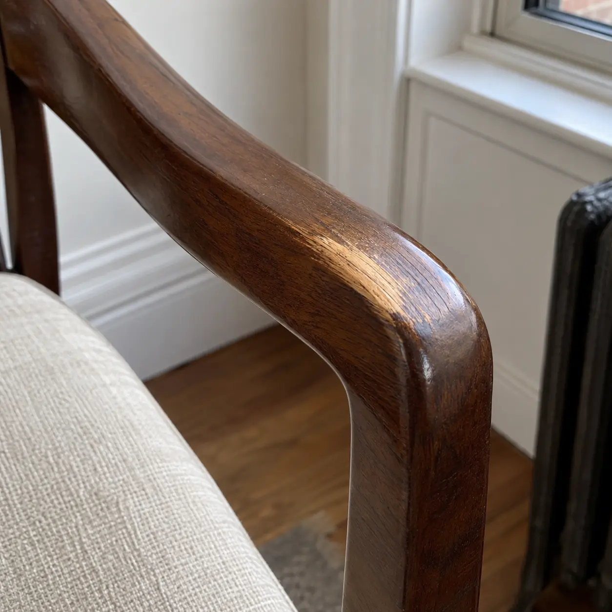 Wood chair arm with the finish worn to bare grain
