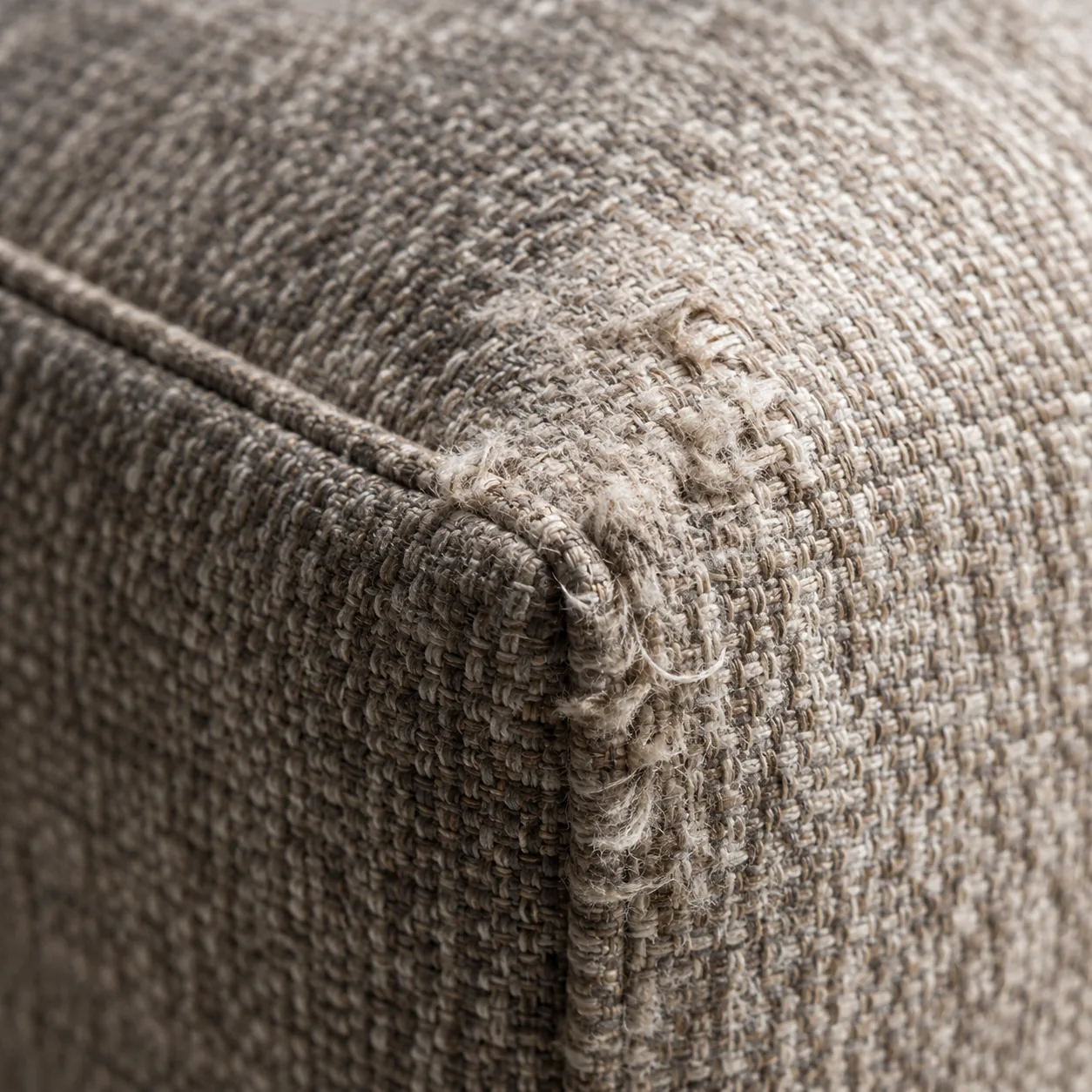 Worn threadbare corner on an upholstered headboard with the weave abraded
